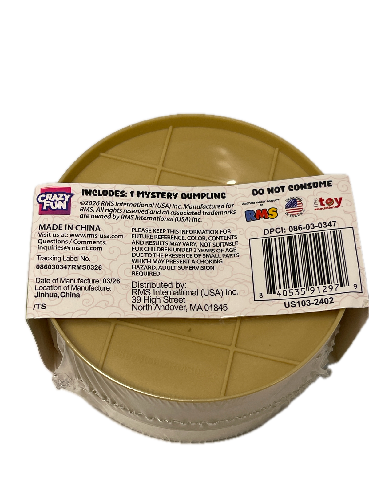 A plastic toy bucket with a tan interior and a clear outer wall, wrapped in a clear plastic sleeve with a white product label attached. The label shows a barcode, product details, and the 'Crazy Fun' brand logo.