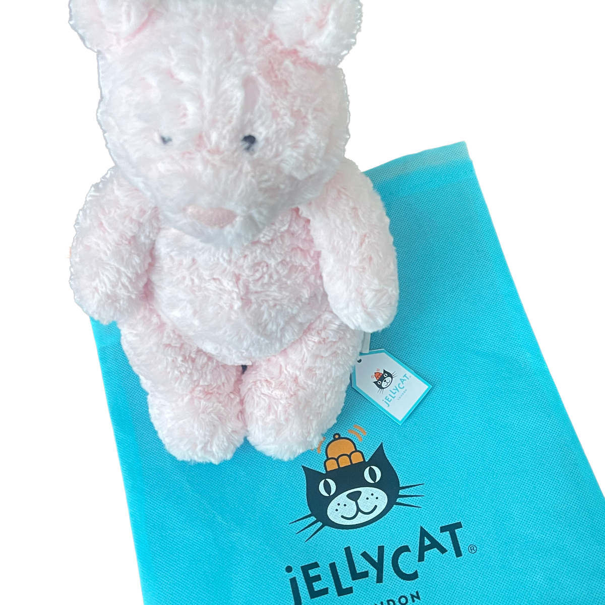 Pink plush toy on a Jellycat branded blue mat