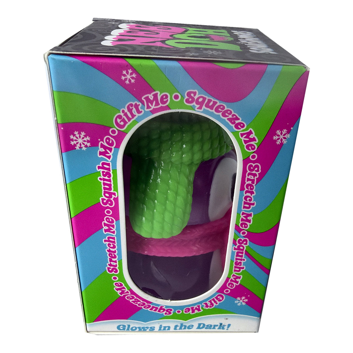 Sex toy packaging box featuring a green textured, snake-like dildo with a purple base and pink strap, visible through a clear window. The box has a colorful pink, green, and blue retro design with text reading 'Gift Me', 'Squeeze Me', 'Stretch Me', and 'Glows in the Dark!'.