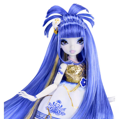 A doll with long, vibrant blue hair styled in a high bow, wearing a white and gold traditional-inspired dress with blue floral patterns, set against a plain white background.