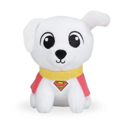 A white plush puppy toy with large black embroidered eyes, a black nose, a yellow collar, and a red cape featuring a yellow and red Superman-style chest emblem, shown on a plain white background.