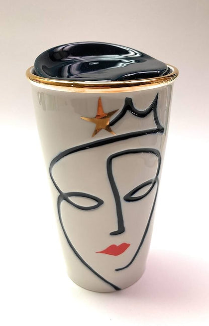 Travel mug with face design and gold accents on a white background