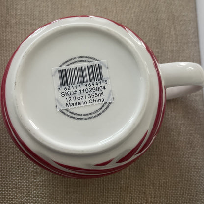 Red and white mug with a barcode label on a brown surface