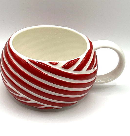 Ceramic mug with red and white striped design on a white background