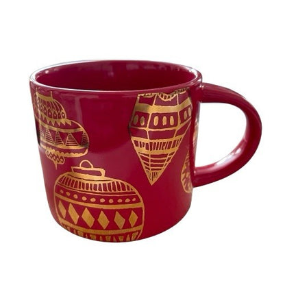 Red mug with gold geometric patterns on a white background