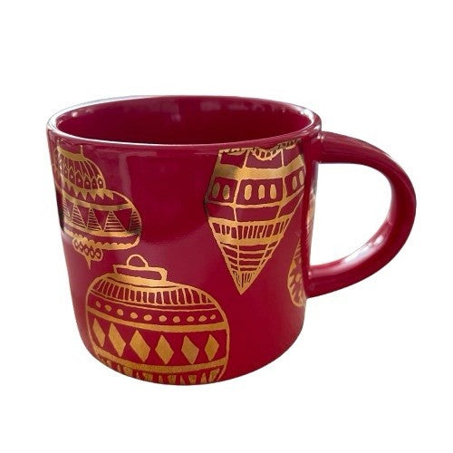 Red mug with gold geometric patterns on a white background