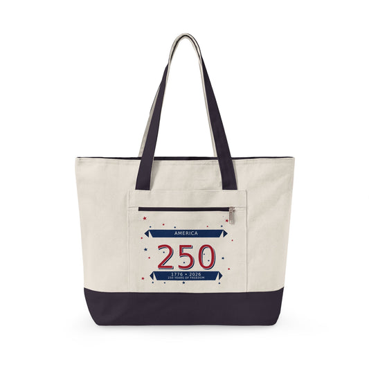 A canvas tote bag with an off-white body, dark navy blue handles and bottom trim, and a front pocket featuring a patriotic '250 America' graphic.