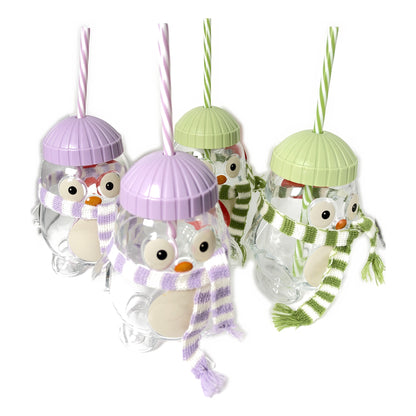 Four Aldi Merry Moments penguin glass sippers, two green and two purple, with knit scarves and striped straws