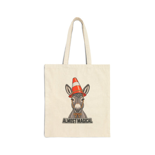 An off-white canvas tote bag with a printed graphic of a donkey wearing an orange and white traffic cone hat, with the text 'ALMOST MAGICAL' below, shown against a plain white background.