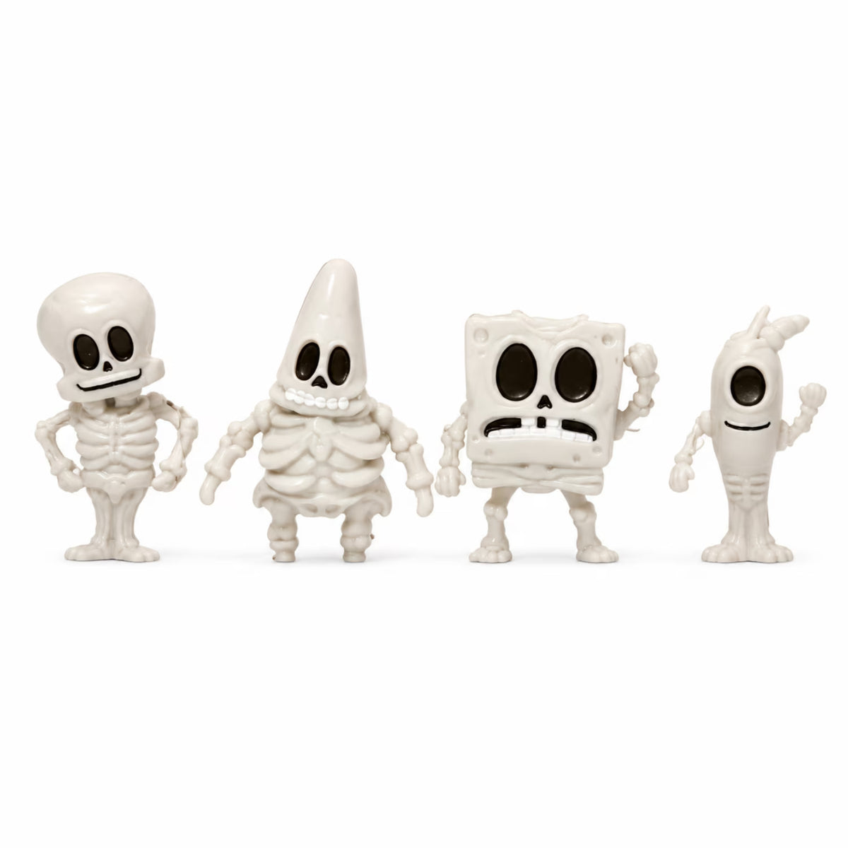 Four white skeleton-themed figurines lined up against a plain white background, each with a different body shape and spooky facial features.