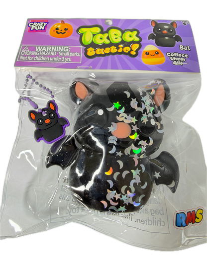 A packaged Halloween-themed squishy toy featuring a black bat with silver moon and star patterns, a purple hanging ball chain, and a purple retail card with 'TeeTaz' branding.