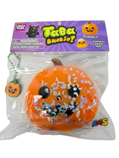 A packaged orange pumpkin squishy toy with a cartoon face, silver star and moon stickers, and a small pumpkin keychain attached, shown in its retail blister packaging on a white background.