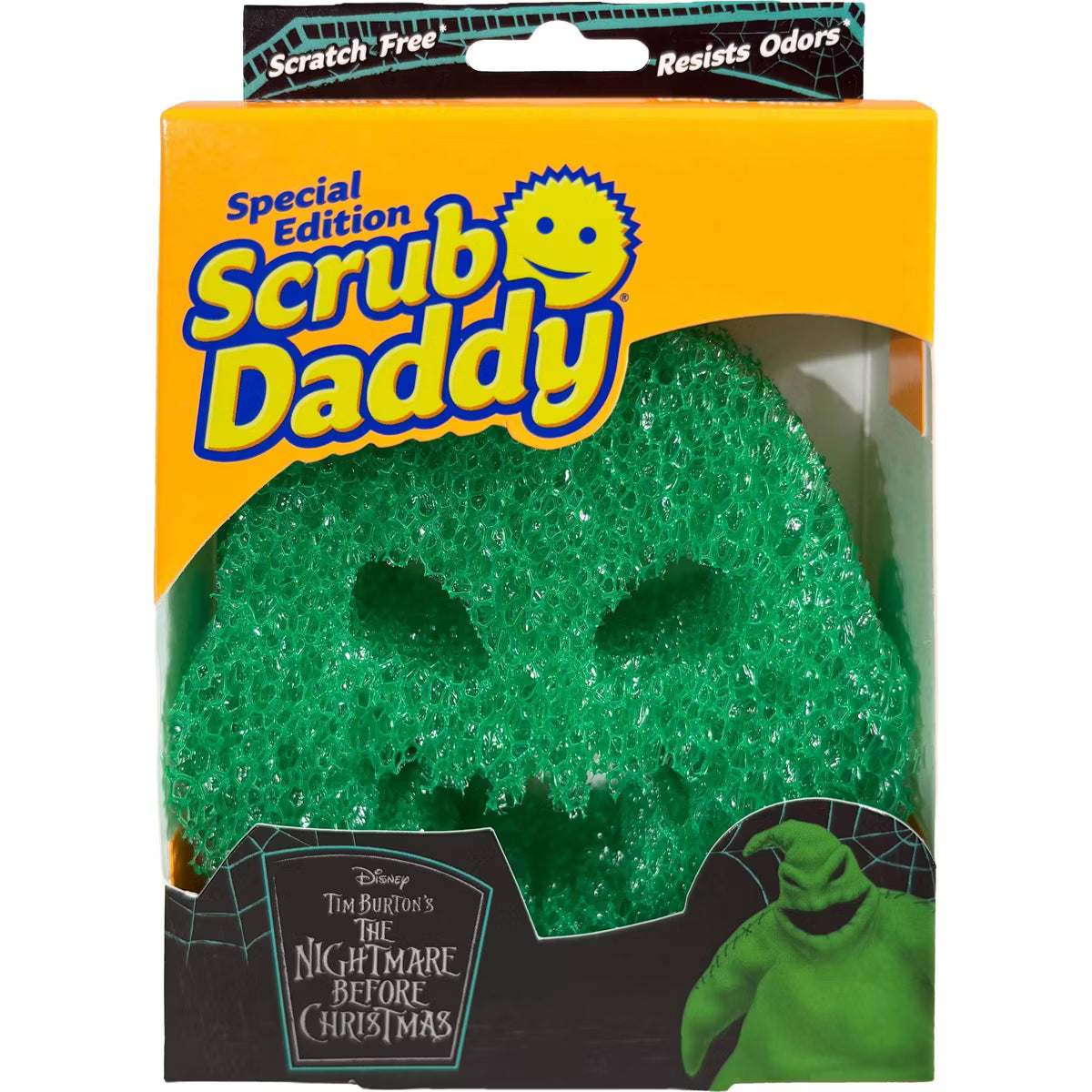 Disney The Nightmare Before Christmas Special Edition Scrub Daddy cleaning sponge in its original retail packaging. The sponge is green with a glittery texture and shaped like a skull, visible through a clear plastic window in an orange and black box.