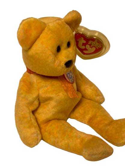 Yellow teddy bear with a visible brand tag on a beige background