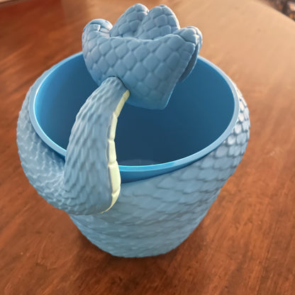 Blue textured cup with a matching dragon-shaped handle on a wooden surface