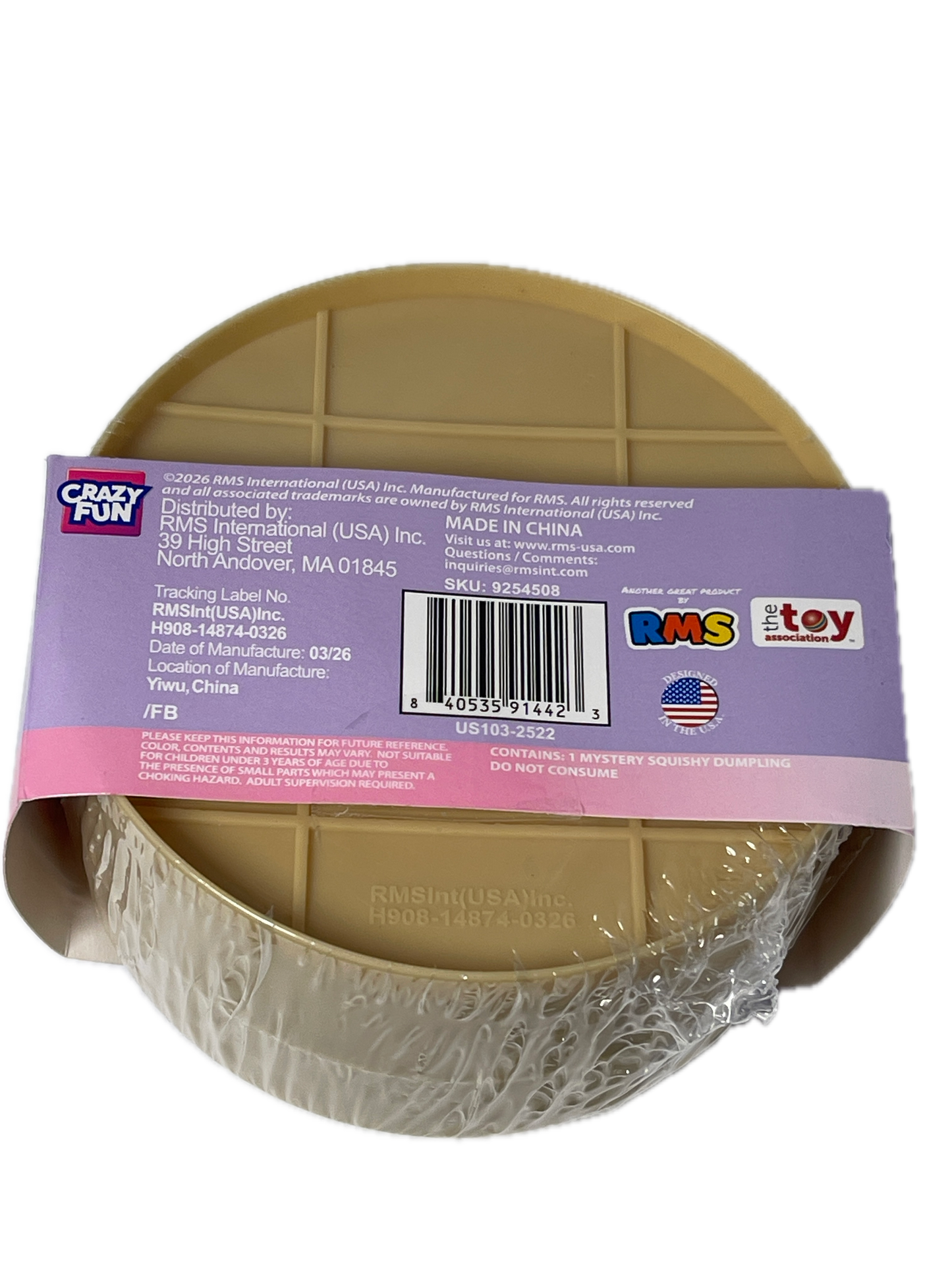 A round plastic toy bowl in a tan/beige color, wrapped in clear plastic and covered with a purple and pink product label. The label shows the brand 'Crazy Port' and various certification logos.