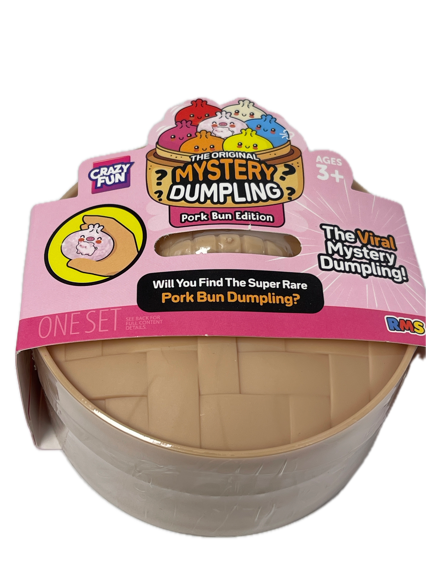 A toy product in a clear plastic dome package with a pink retail card. The item inside appears to be a beige textured cylindrical toy or container labeled 'The Mystery Dumpling' and 'Pork Bun Edition.