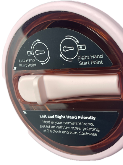 Close-up of a circular plastic bottle cap with a translucent amber-brown interior, a white central pull tab, and printed instruction labels showing how to open it with the dominant and left hand.