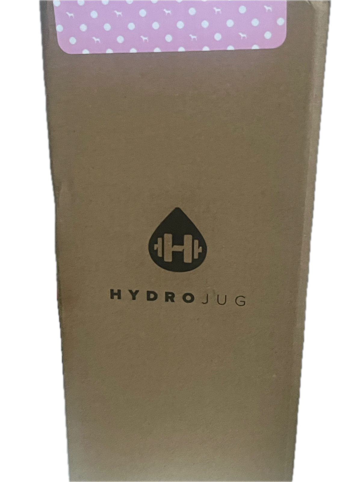 A close-up of a brown cardboard box with a black printed logo and the word 'HYDROJUG' on the side, next to a pink label with white polka dots.