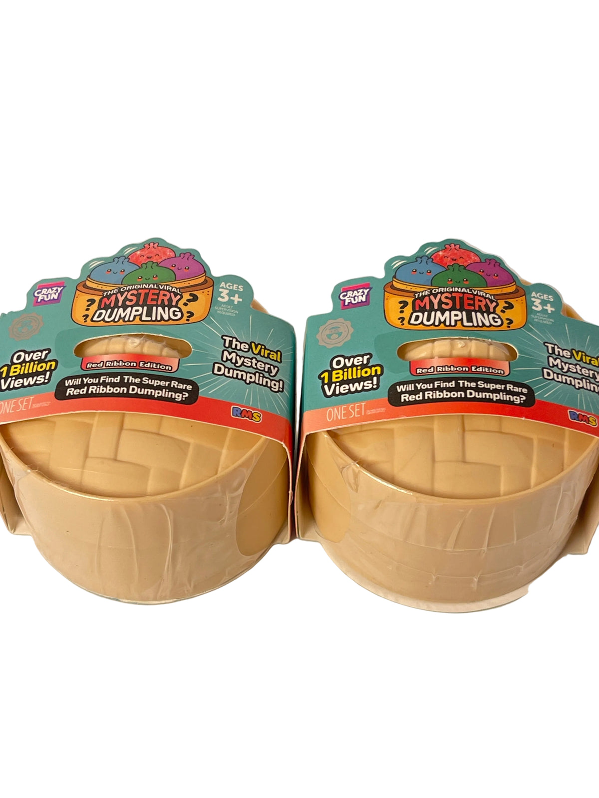 Two packages of Fox Toys Mystery Dumplings shown side by side on a plain light background. Each package contains a beige crimped dumpling inside a clear plastic container, with colorful retail labels above.