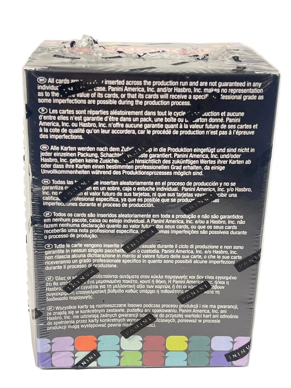 The back of a sealed black card deck box, showing printed warranty and care instructions in multiple languages, with a row of small illustrated card colors along the bottom edge and several black sticker seals across the front.