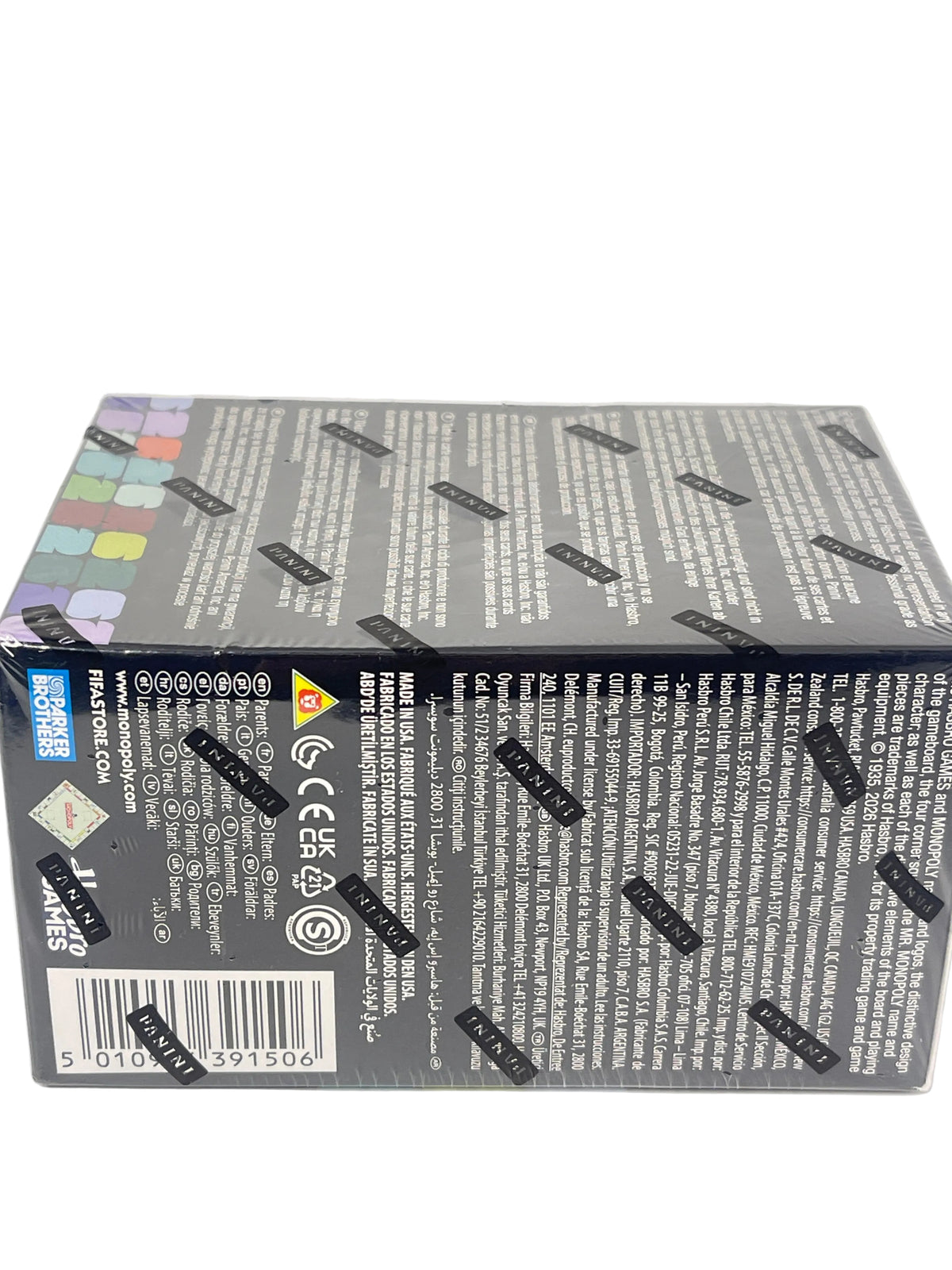 The back of a sealed Pokémon Trading Card Game booster box, showing dense white text, barcodes, and multiple black 'MADE IN USA' stickers on a light gray background.
