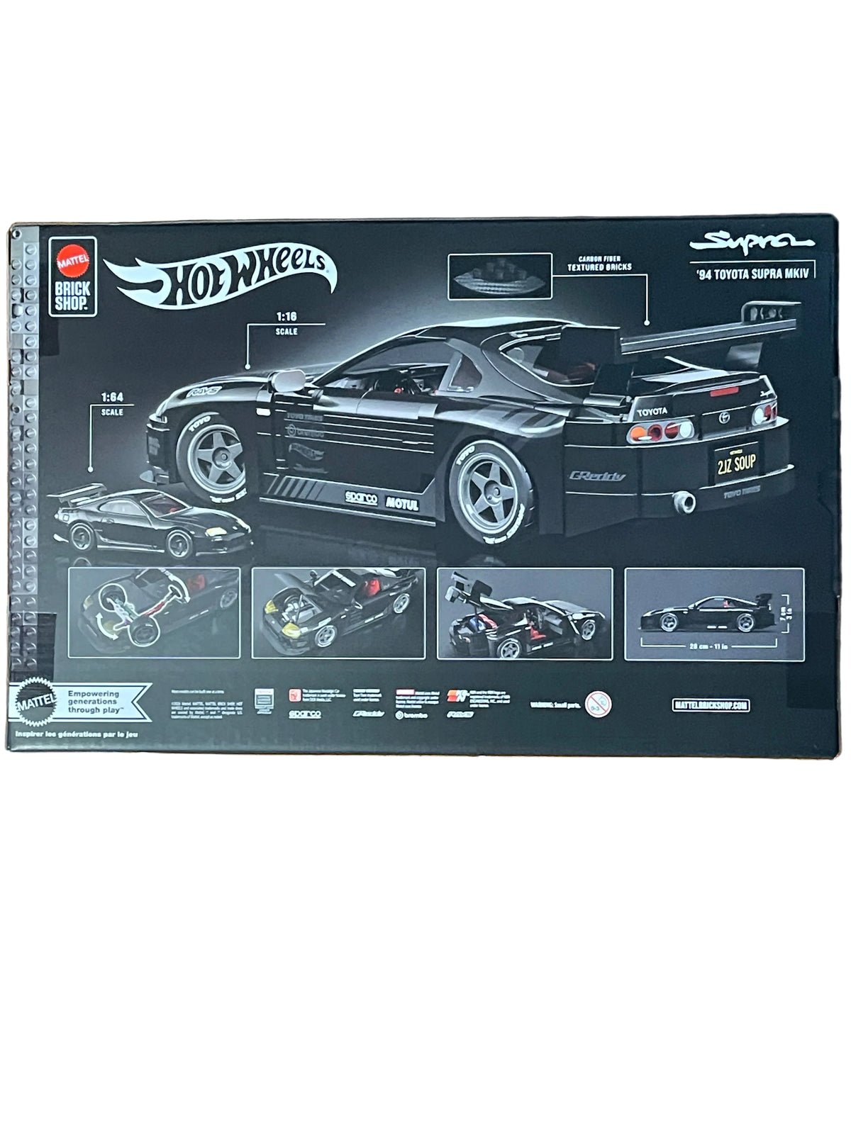 Hot Wheels Super Spyra model car packaging box displayed on a wooden floor, showing a black Toyota Supra Nismo 1:12 scale model car.