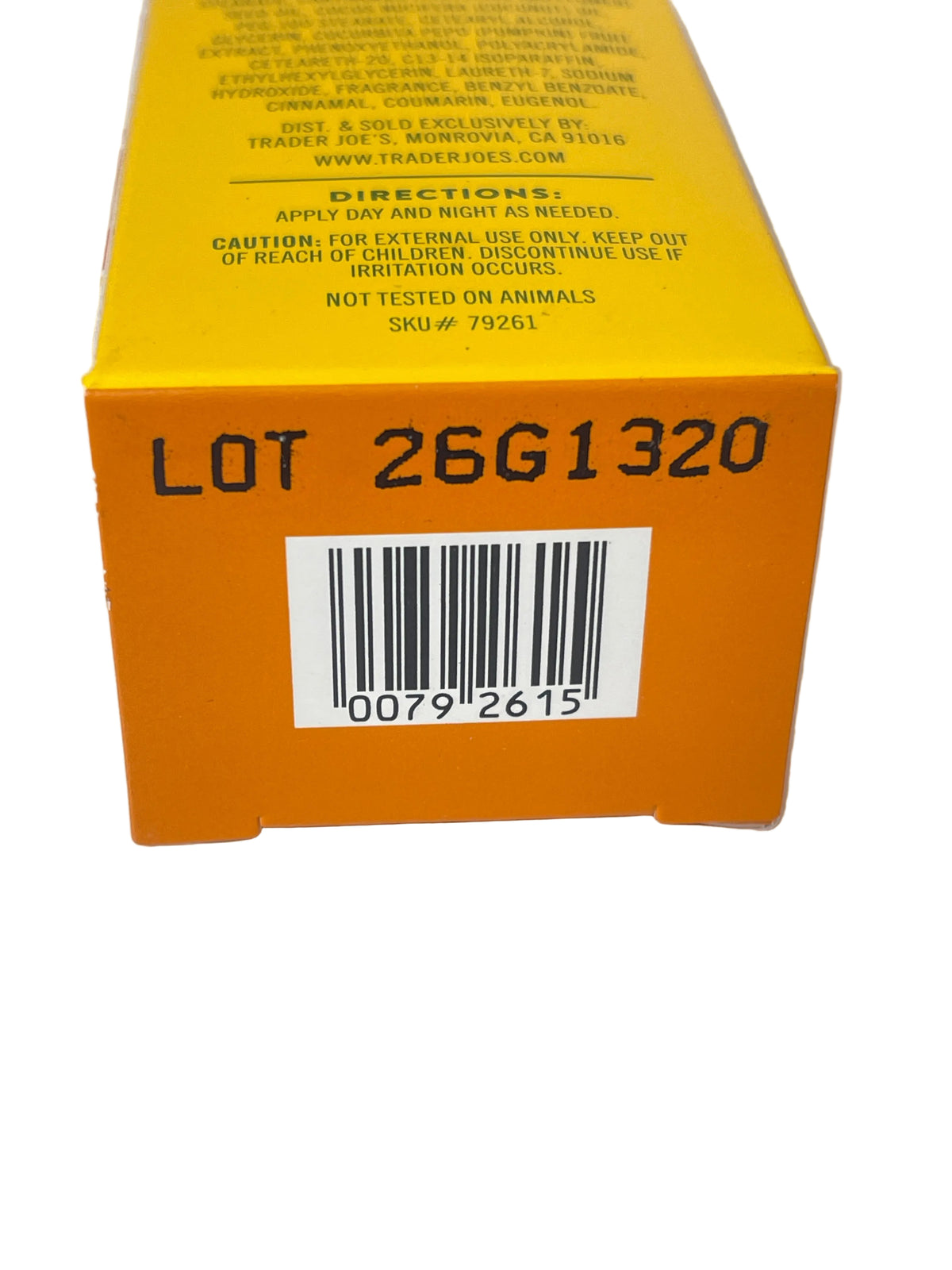 Close-up of the side of a bright orange product box showing printed text, a barcode, and lot number 26G1320 on a white background.