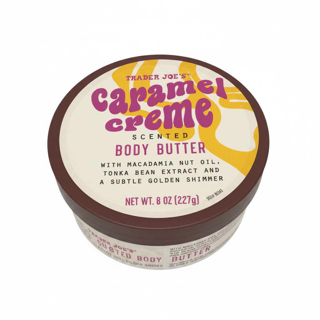 A round tin of Trader Joe's Caramel Creme Scented Body Butter on a white surface. The lid features a cream background with a yellow graphic and bold pink text, and a dark brown rim.