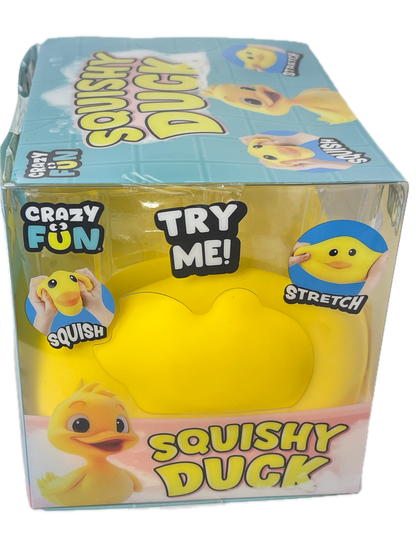 A yellow rubbery squishy duck toy in clear retail packaging with printed graphics and text including 'SQUISHY DUCK' and 'TRY ME!'.