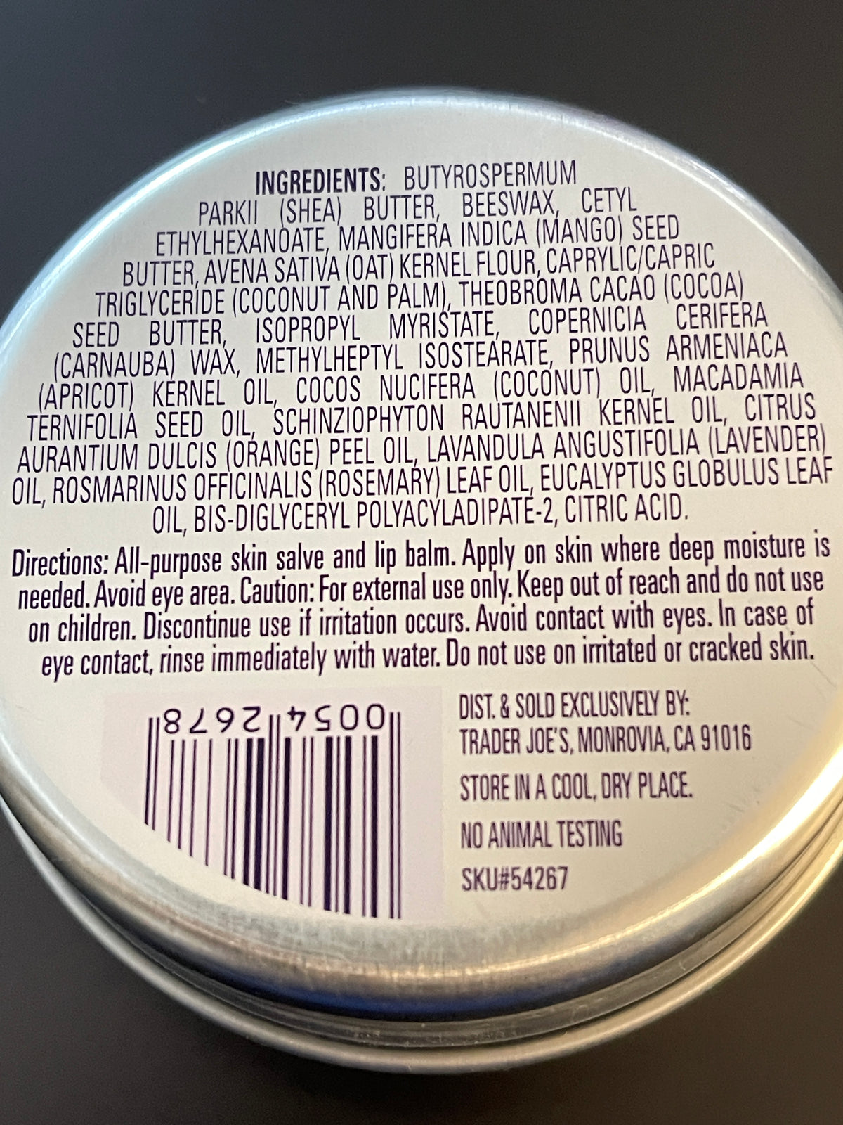 The back of a circular jar lid showing the ingredients and directions for a butyrospermum hair care product in dark purple text on a white background.