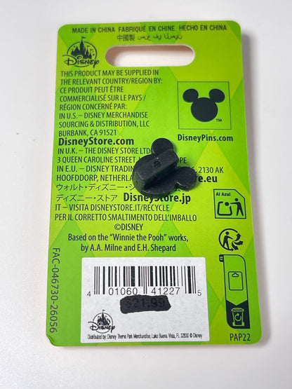 A black Mickey Mouse-shaped pin attached to a bright green Disney store blister card, photographed against a plain white background.