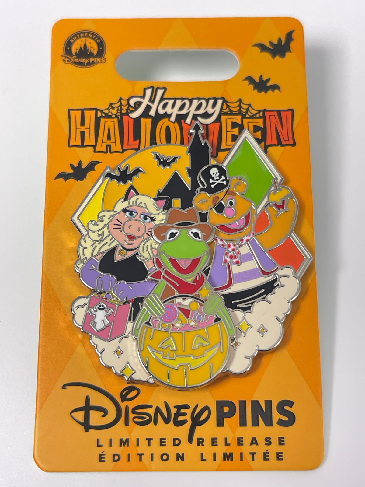 A Disney Mupp Halloween-themed enamel pin on its original orange backing card. The pin features Kermit the Frog, Miss Piggy, Fizz Piggy, and Gonzo in Halloween costumes.