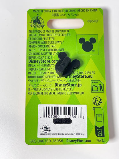 A black Mickey-shaped cardholder or pin backing card from Disney, featuring product information, a barcode, and a small black Mickey-shaped accessory attached to the card.