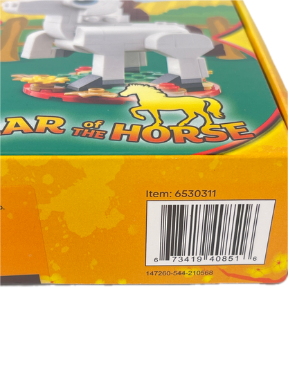 Close-up of a toy box corner showing a yellow side panel with a barcode and part of a green front illustration featuring the text 'AR OF THE HORSE' and a horse graphic.