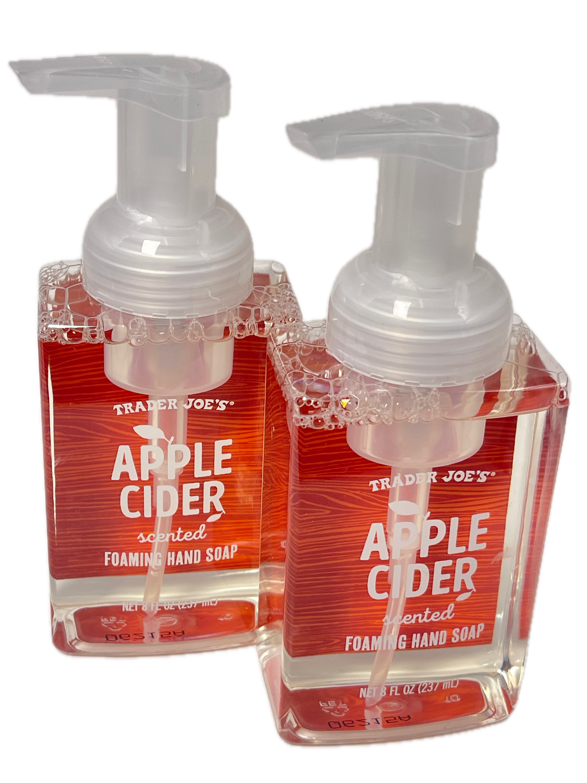 Two small Trader Joe's scented apple cider foaming hand soap bottles with clear pump tops, stacked diagonally on a white background.