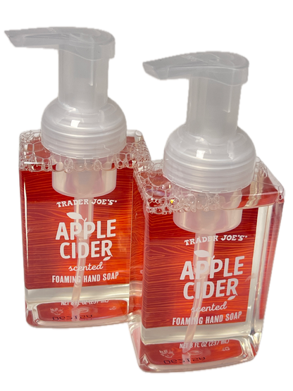 Two small Trader Joe's scented apple cider foaming hand soap bottles with clear pump tops, stacked diagonally on a white background.