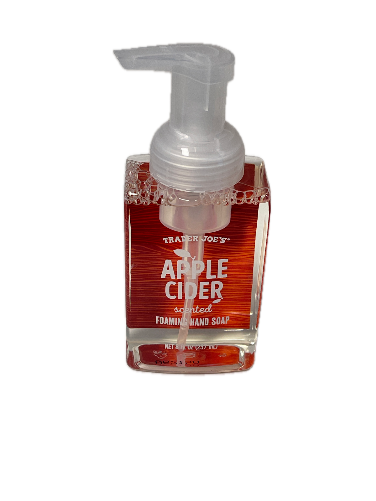 A bottle of Trader Joe's Apple Cider scented foam hand soap, showing the clear pump dispenser and red liquid inside a clear bottle with a red label, isolated on a white background.