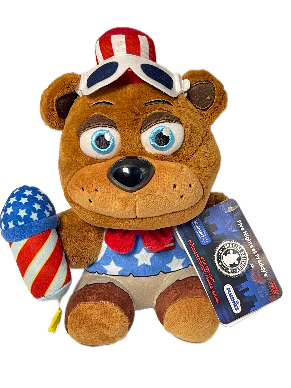 A plush teddy bear toy with a patriotic American flag theme, featuring a red, white, and blue star-spangled body, a matching star-spangled hat, and a blue hangtag that reads 'Five Biggest Freddy's' and 'PUSHINS'.