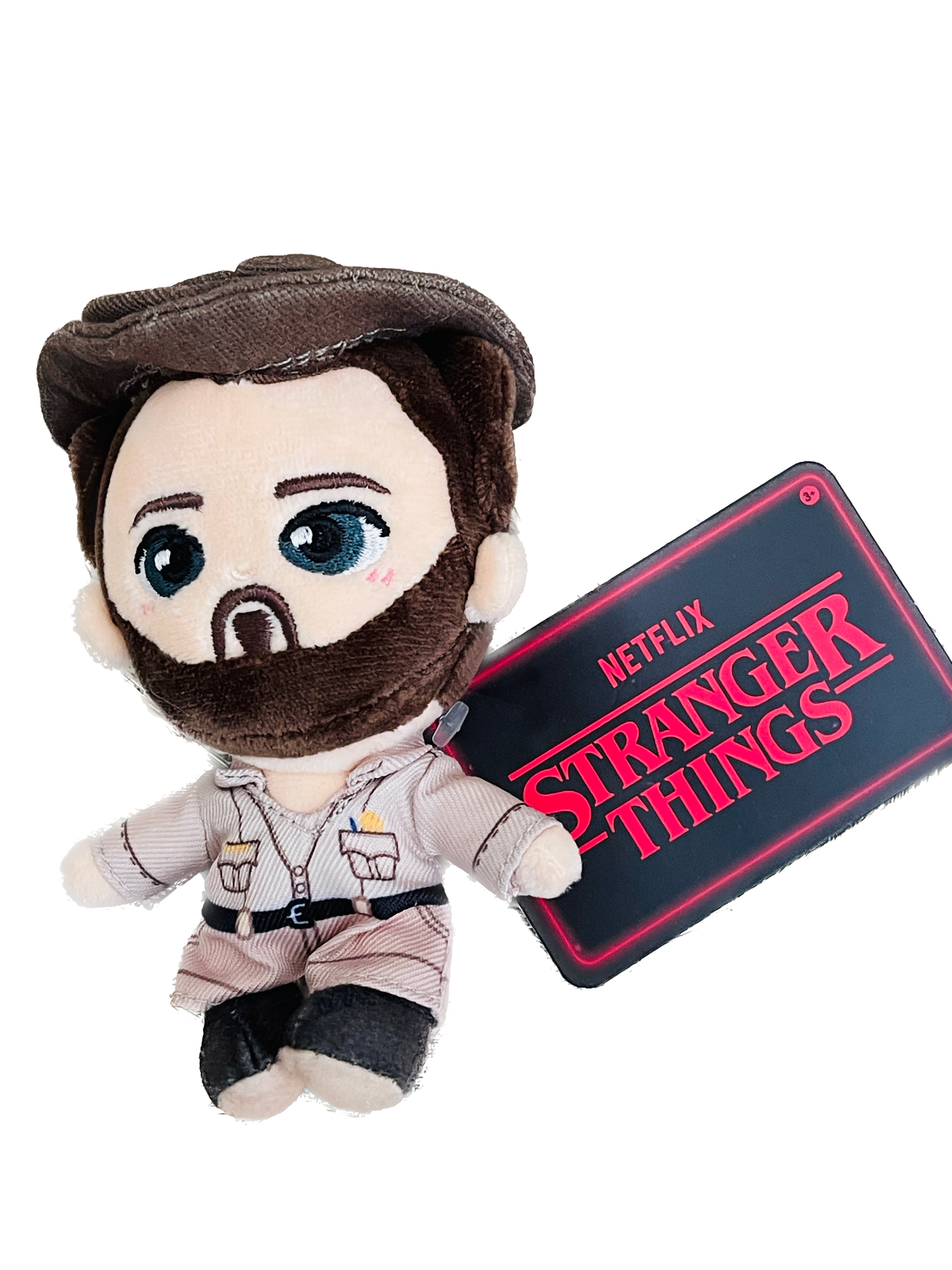 Plush toy of a character from 'Stranger Things' holding a sign with the show's logo on a white background.