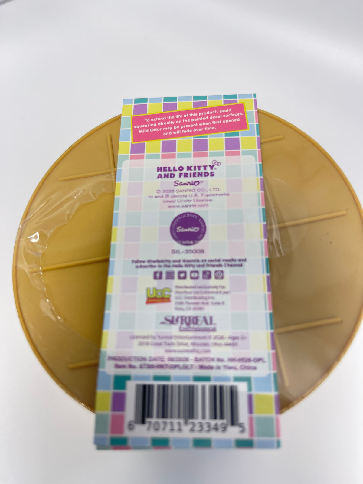 The back of a colorful Hello Kitty and Friends Sailor! Silkworm QLP sticker sheet box by Super Real, placed on top of a gold circular plastic tray.