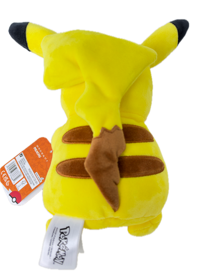 A yellow Pikachu plush toy with black-tipped ears and tail, brown ear patches, and a brown lightning-bolt detail on its back, shown on a white background with an orange retail hangtag and a white Pokémon brand tag.