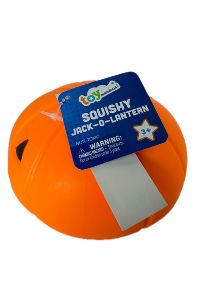 An orange squishy jack-o'-lantern toy with a blue and white product tag attached, photographed on a solid white background.