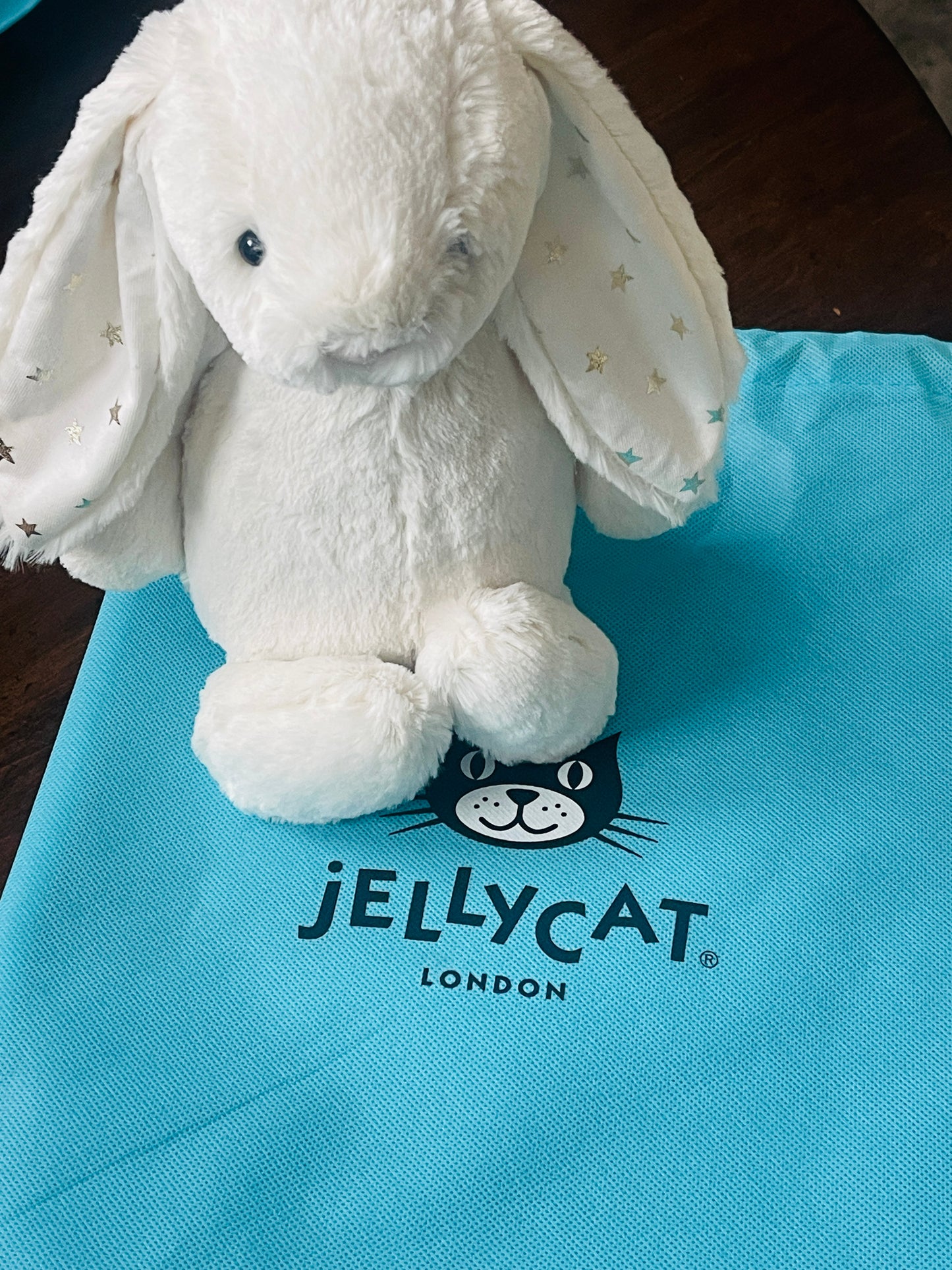 White plush toy on a blue Jellycat London bag