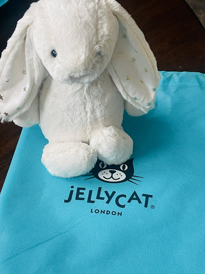 White plush toy on a blue Jellycat London bag
