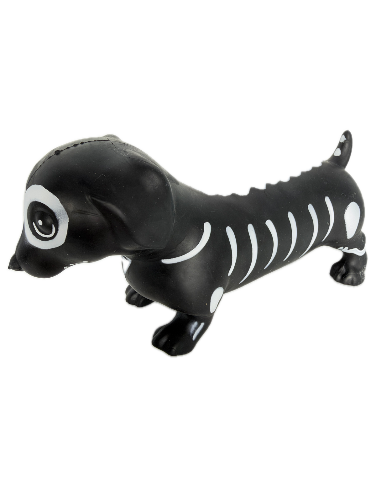 A SQUISHY black and white skeleton dog toy floating vertically against a solid white background.