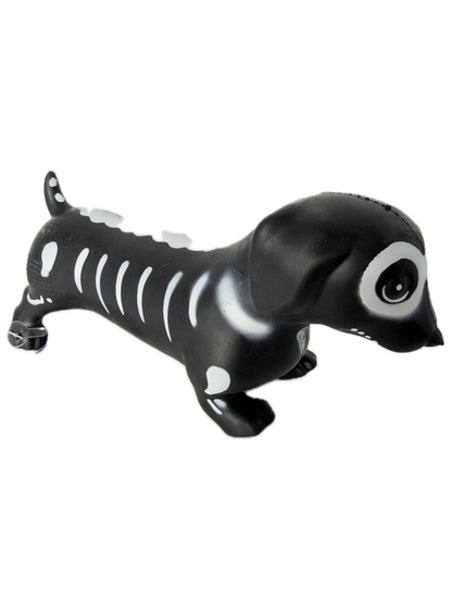 A black and white SQUISHY WEINER DOG shaped like a skeleton, standing upright on its hind legs against a plain white background.