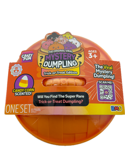 A toy product in retail packaging, featuring a round orange plastic container with a hinged lid and a cardboard sleeve. The packaging is orange, yellow, and black with text including 'Mystery Dumpling', 'The Viral Worst Dumpling!', 'Trick-or-Treat Dumpling?', and 'Candy Cane Scented!'.