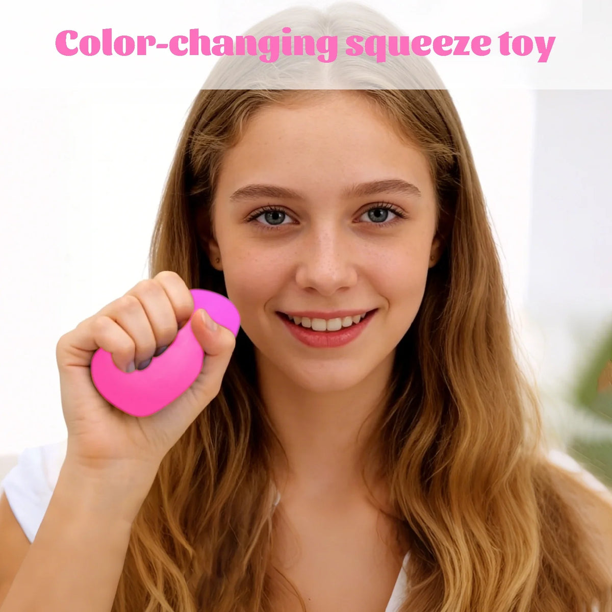 Person holding a pink color-changing squeeze toy with text above