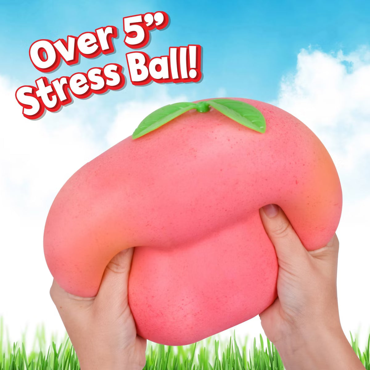 Pink stress ball with green leaf held by hands against a blue sky and grass background